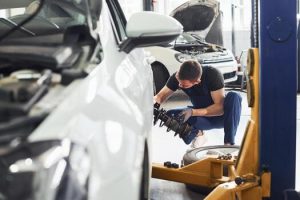 man-in-work-uniform-repairs-car-indoors-conception-of-automobile-service-free-photo